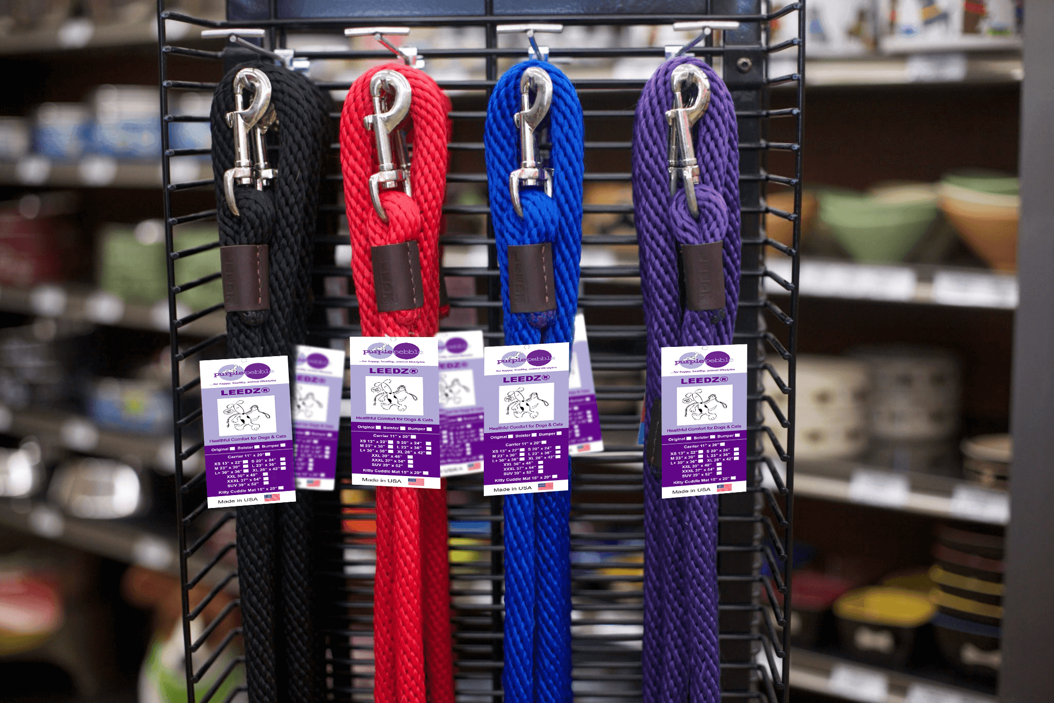 Colorful dog leashes displayed on rack.